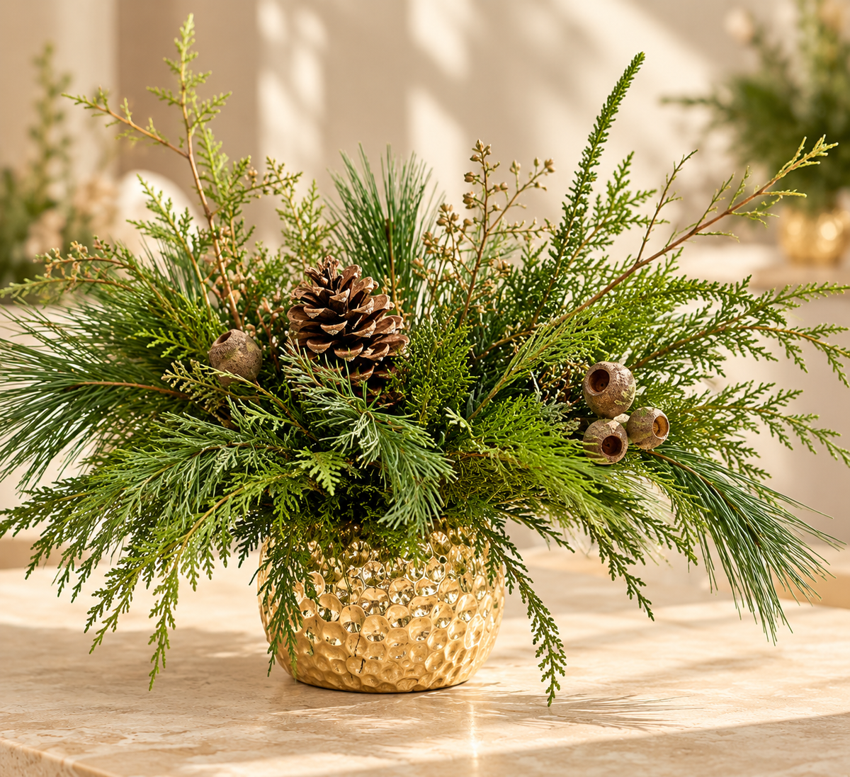 Christmas centerpiece with evergreens, acorns and candles in a gold container