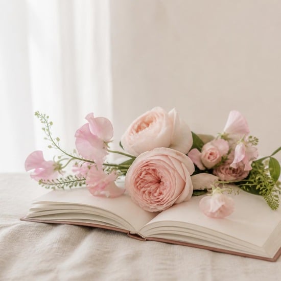 Open book with blush pink garden roses and sweet peas laid across the pages, The Bloom Room floral book club at April Flowers in Burnaby